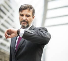 Busy businessman checking his watch most stressful jobs, meetings