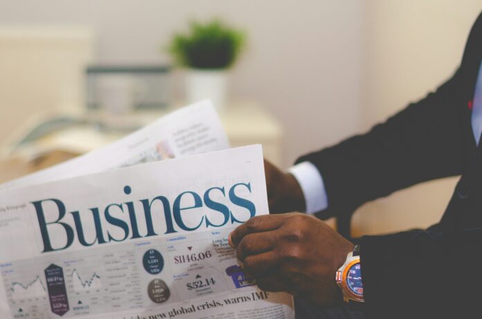 adeolu-eletu-E7RLgUjjazc-unsplash man in suit holding business newspaper for Cvent acquires Reposite announcement
