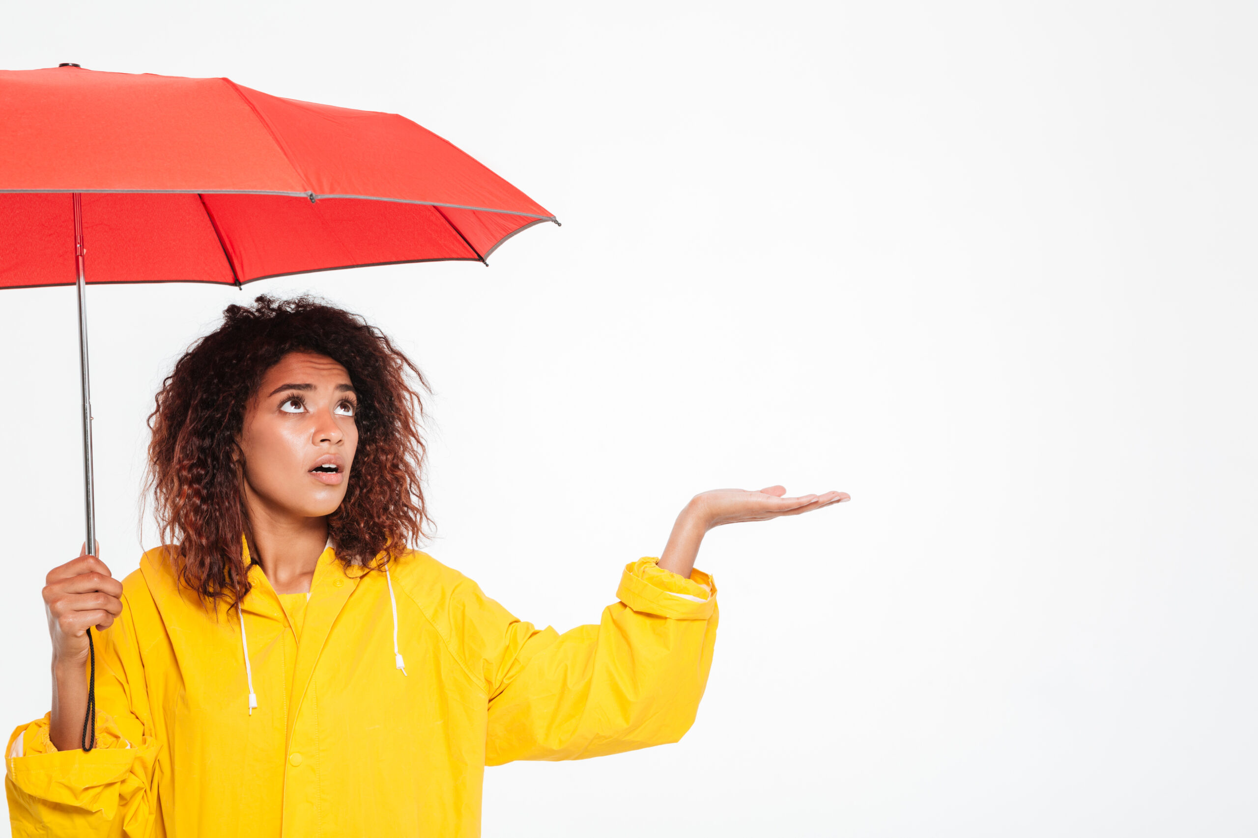 Black woman in raincoat with red umbrella
